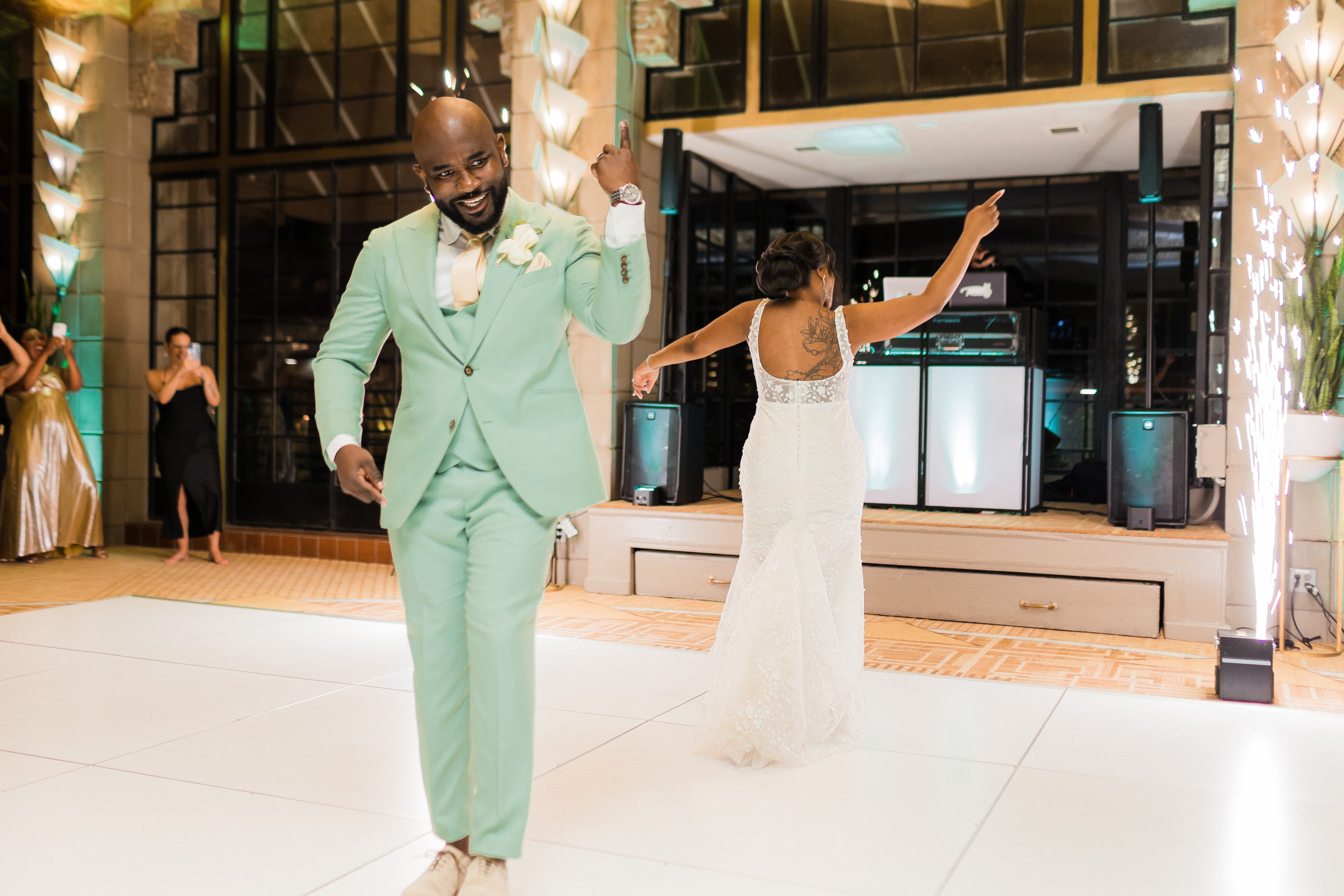 Groomsmen and bride dancing under string lights